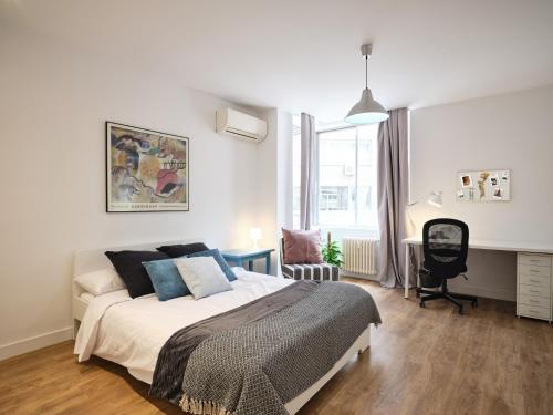 a white bedroom with a bed and a desk at My City Home - Fantastic apartament at Moncloa for students in Madrid