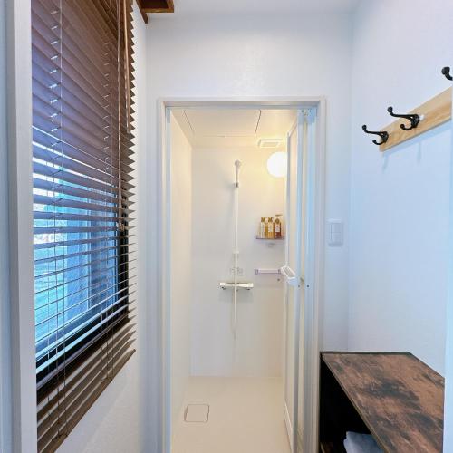 uma casa de banho com uma cabina de duche ao nível do chão ao lado de uma janela em 【三米通天閣】602-6FB難波商圈天王寺心斎橋10min em Osaka