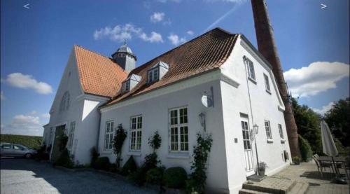 ein weißes Haus mit einem Leuchtturm darüber in der Unterkunft Small cosy appartment in Skanderborg