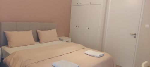 a bedroom with a bed with two towels on it at Hermes green in Artemida