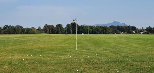 a field with a flag in the middle of it at CLUB HOUSE - ASD Sacramento Golf in Sabaudia