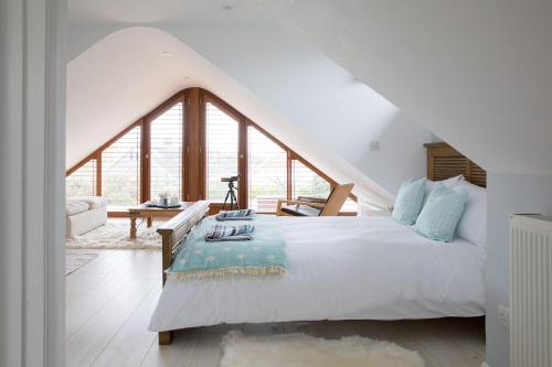 a bedroom with a white bed with a large window at Family Seaside Retreat - 5 minutes to Beach in West Wittering