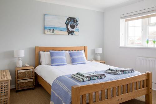 a bedroom with a bed with a dog picture on the wall at Family Seaside Retreat - 5 minutes to Beach in West Wittering