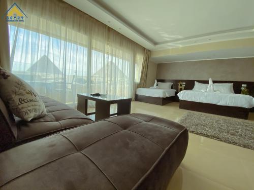 a large room with two beds and a couch at Egypt Pyramids Inn in Cairo