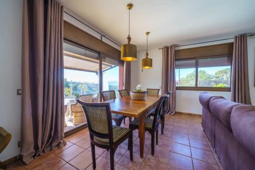 a dining room with a table and chairs and a couch at Villa Silence Lux with Pool in Nature and Aircon in Maçanet de la Selva
