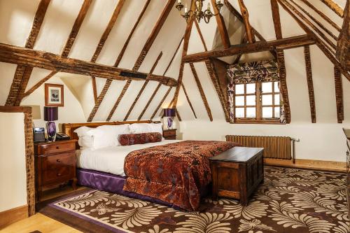 a bedroom with a bed in a room with beams at Lainston House in Winchester