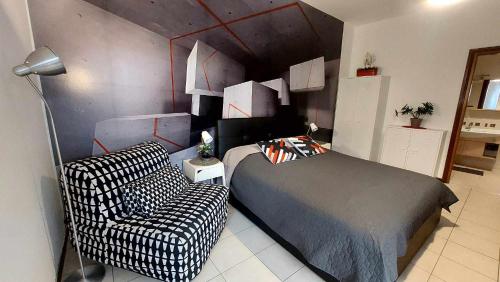 1 dormitorio con 1 cama y 1 silla en B&B GoodDay Roma Tor Vergata, en Tor Vergata