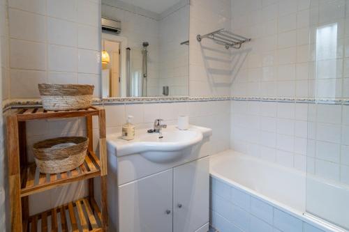 een witte badkamer met een wastafel en een bad bij Siempre Verde in Alcaucín
