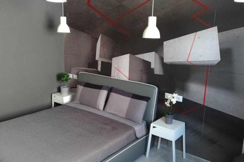1 dormitorio con 1 cama y 2 mesas en B&B GoodDay Roma Tor Vergata, en Tor Vergata
