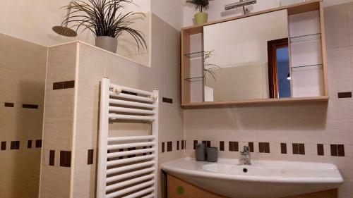 y baño con lavabo y espejo. en B&B GoodDay Roma Tor Vergata, en Tor Vergata