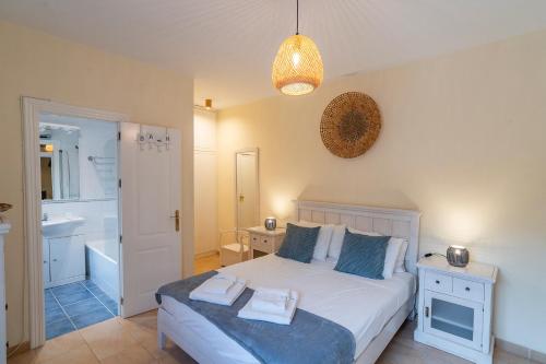 a bedroom with a white bed and a bathroom at Siempre Verde in Alcaucín