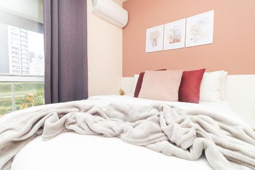 a bedroom with a white bed with a blanket at Vossa Bossa VN Turiassu in Sao Paulo