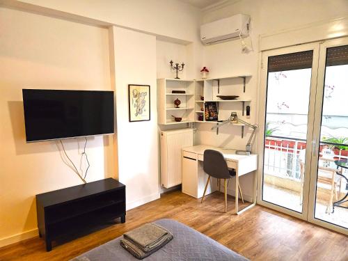 a living room with a desk and a flat screen tv at Plato's Academy Home in Athens