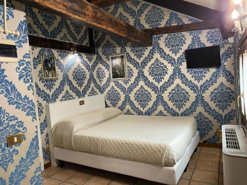 a bedroom with blue and white wallpaper and a bed at Hotel Bridge in Venice