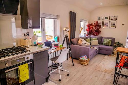 a kitchen and living room with a couch and a table at The Violet Corner 3, Modern & Comfy 2 Bed Home in Cardiff