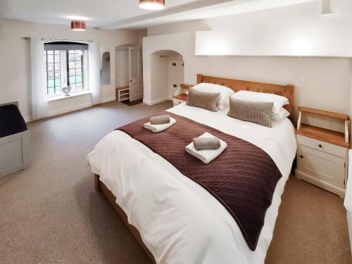a large bedroom with a large bed with two pillows on it at The Brew House in Tideswell