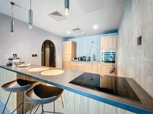 a kitchen with a counter and two stools in it at Key View - Hub Canal 1 in Dubai
