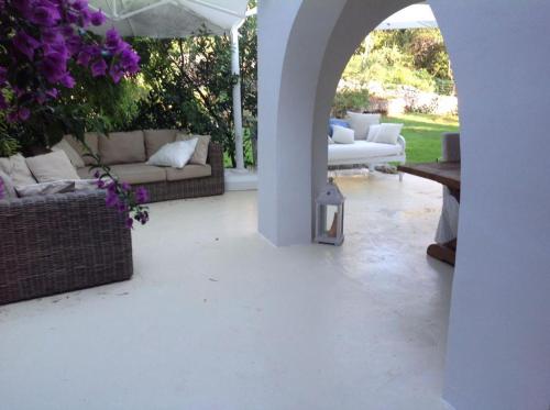 patio con divani, tavoli e ombrellone di Villa a Rosa Marina con piscina a 300 m. dal mare a Rosa Marina