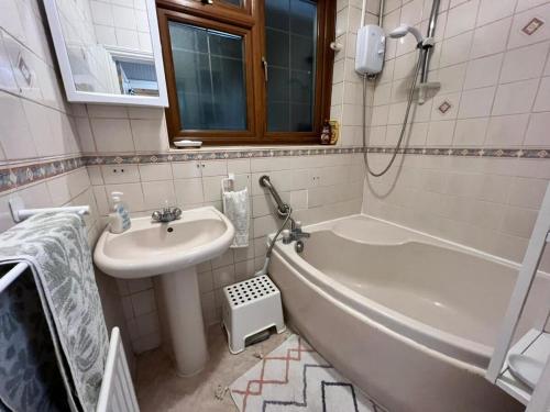 a bathroom with a sink and a bath tub next to a sink at LiveStay Room with Free Parking in Wembley in London