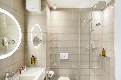 a bathroom with a shower and a toilet and a sink at Austria Trend Hotel Bosei Wien in Vienna
