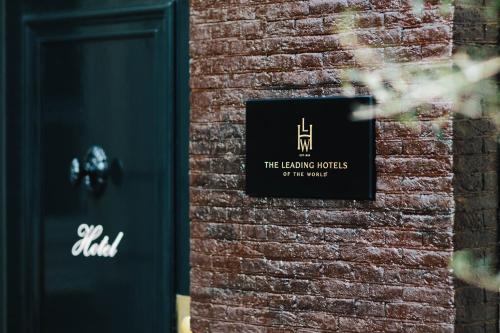 a sign on the side of a brick wall at The Dylan Amsterdam - The Leading Hotels of the World in Amsterdam