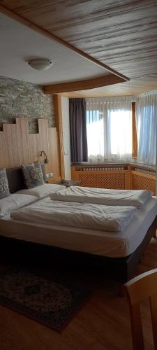 a large bed in a room with a window at Hotel Giusy in Malosco