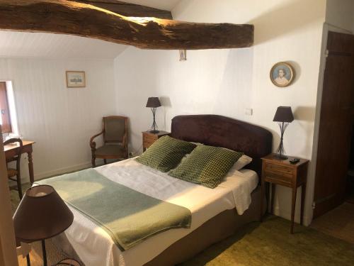 a bedroom with a bed and a desk and a chair at La Maison des Gardes - Chambres d'hôtes in Cluny