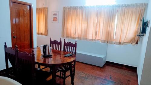 uma sala de jantar com uma mesa e cadeiras e uma mesa sidx sidx sidx em Deer Suites and Spa- Rock Beach White Town Zone , French Quarter, Pondicherry em Pondicherry