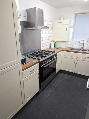 a kitchen with white cabinets and a stove top oven at Above us only sky in Kirkby