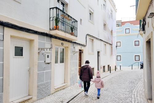 a man and a child walking down a street at Casa do Sr. Elias in Sesimbra