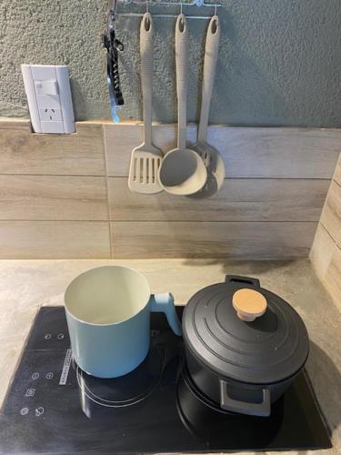 a stove top with a coffee pot and utensils at lo de lucio in Almafuerte