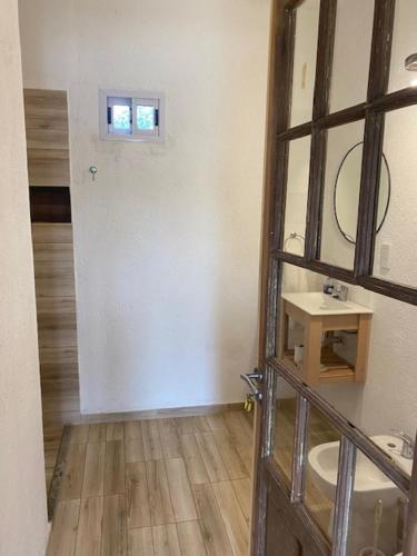 a bathroom with a sink and a door with a mirror at lo de lucio in Almafuerte