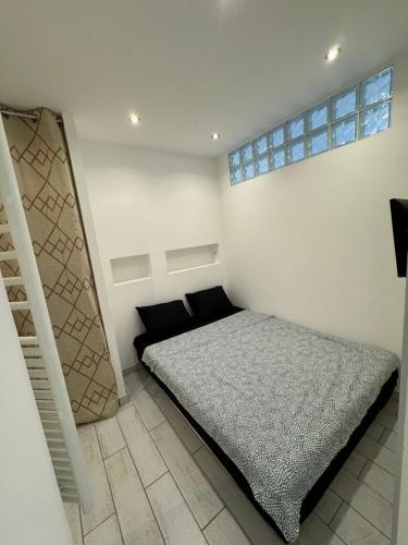 une petite chambre avec un lit et un escalier dans l'établissement Appartement t2 résidence cap liouquet, à La Ciotat