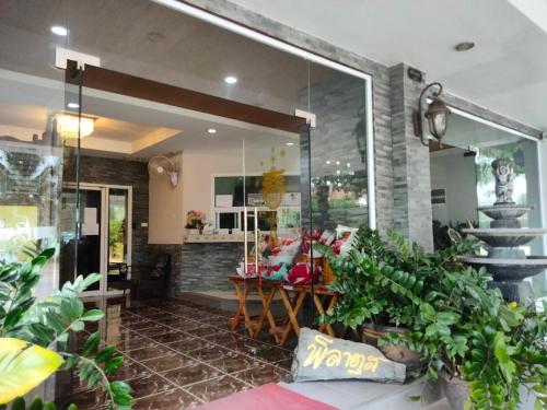 a lobby of a store with plants and a staircase at Pilatus Apartment in Loei