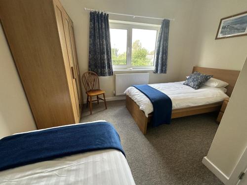 um quarto de hotel com duas camas e uma janela em Immaculate 2 bedroom bungalow close to beaches em Pendine