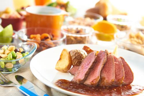 un piatto di carne e pane e altri alimenti su un tavolo di Kawasaki King Skyfront Tokyu REI Hotel a Kawasaki