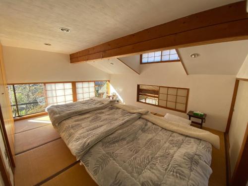 a large bed in a room with windows at kakayama hutte in Muraoka