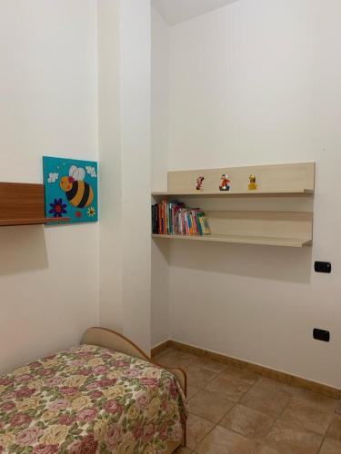 a bedroom with a bed and a shelf with books at VILLA LUPINO in Orosei