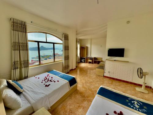 um quarto de hotel com uma cama com flores vermelhas em Cat Ba Plaza hotel em Ilha de Cát Bà