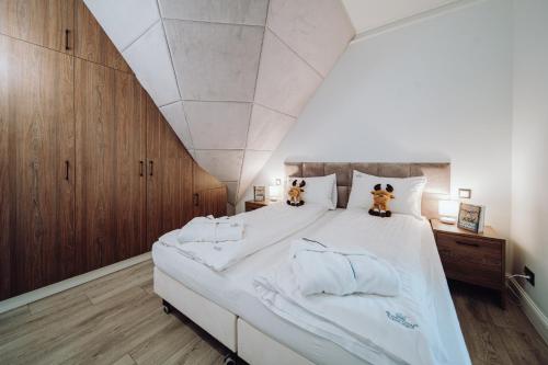 a bedroom with a large bed with two teddy bears on it at Norweska Dolina Family&Pet-friendly Resort in Szklarska Poręba