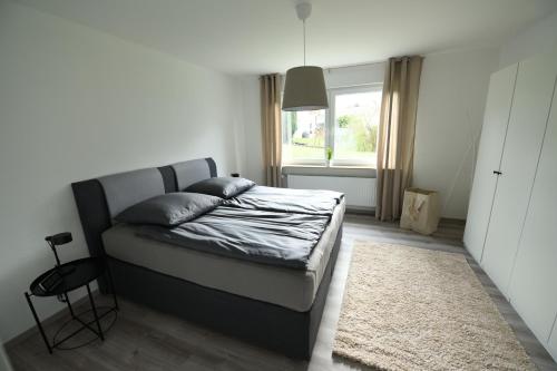 een slaapkamer met een bed en een raam bij Ferienwohnung Niestetal in Niestetal