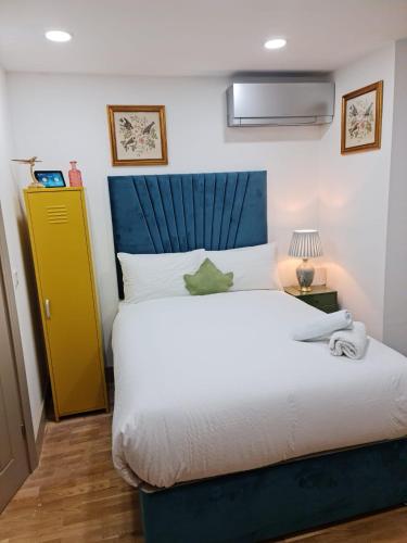 a bedroom with a large bed and a yellow cabinet at SureBillionaire Home Deluxe Queen Studio in London