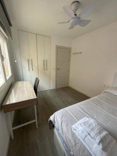 una camera con letto, scrivania e ventilatore a soffitto di Bellalona a Granada