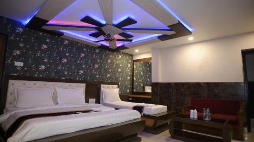 a bedroom with two beds and a ceiling fan at Ananya Hotel in Digha