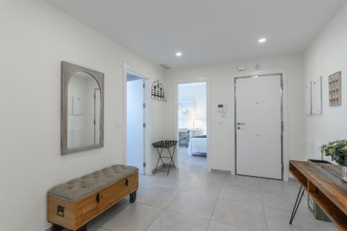 - un salon avec un banc et un miroir dans l'établissement Ocean Homes by Ĥ - Playa de los Haraganes HOHH7104P70, à Isla Canela