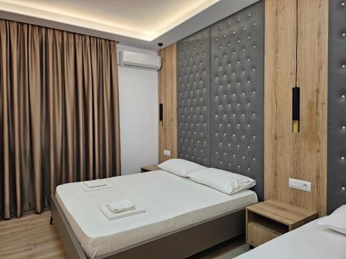 1 dormitorio con 1 cama y pared de madera en Vila Anxhelo en Ksamil