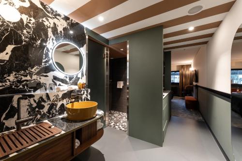 a bathroom with a sink and a mirror at The Home Hotel Zürich - a member of DESIGN HOTELS in Zürich