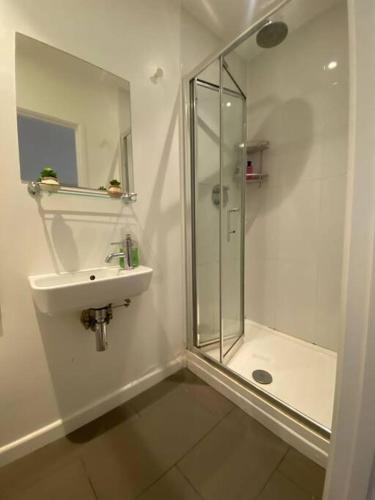 uma casa de banho branca com um lavatório e um chuveiro em Sleep6 Flat at Iconic Piccadilly circus VR6 em Londres