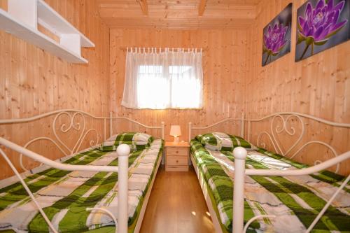 two beds in a small room with a window at Domki Bahama in Bobolin