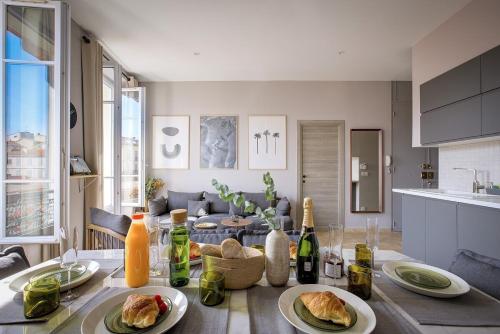 - une table avec des assiettes de nourriture dans la cuisine dans l'établissement Magnifique 4 pièces Forville - Proche Palais des Festivals, à Cannes